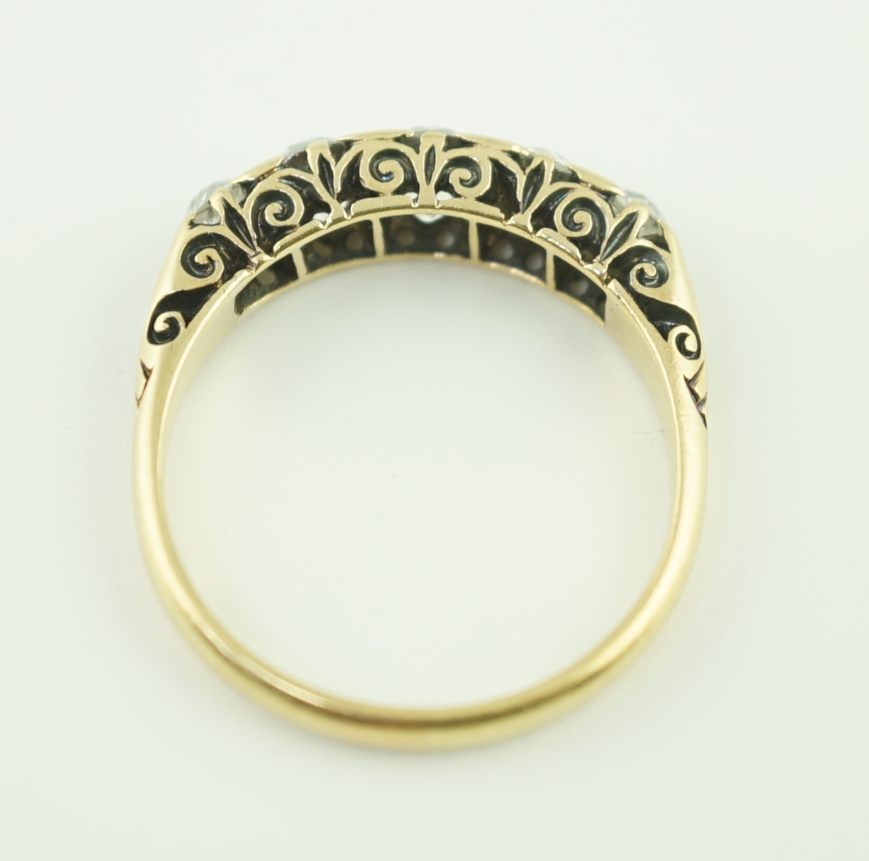 An early 20th century 18ct gold and graduated five stone old cut diamond set half hoop ring